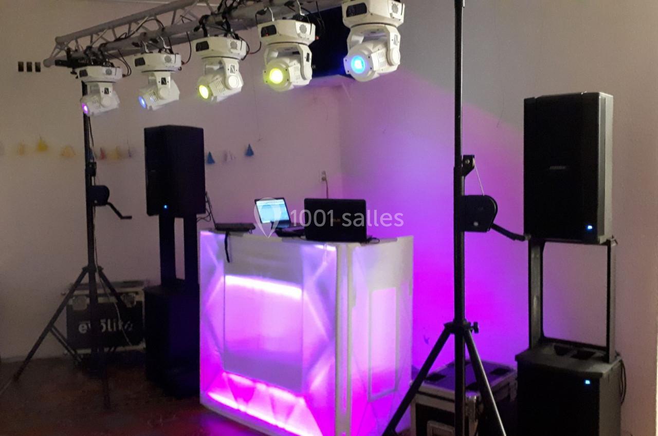 Installation de matériel de sonorisation et d'éclairage avec une table de mixage et des projecteurs colorés.