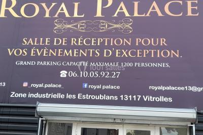 Façade d'une salle de réception avec enseigne indiquant le nom, la capacité et les coordonnées de contact.