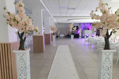 Façade d'une salle de réception avec enseigne indiquant le nom, la capacité et les coordonnées de contact.