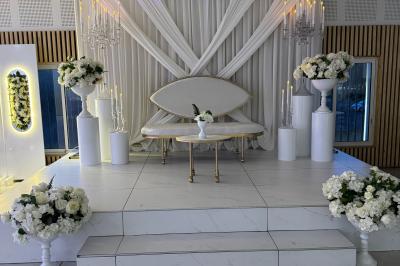 Façade d'une salle de réception avec enseigne indiquant le nom, la capacité et les coordonnées de contact.