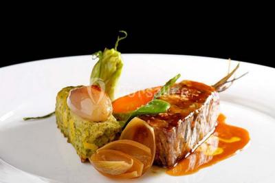Gâteau de mariage décoré avec des choux, des fleurs en sucre et des cierges magiques allumés.
