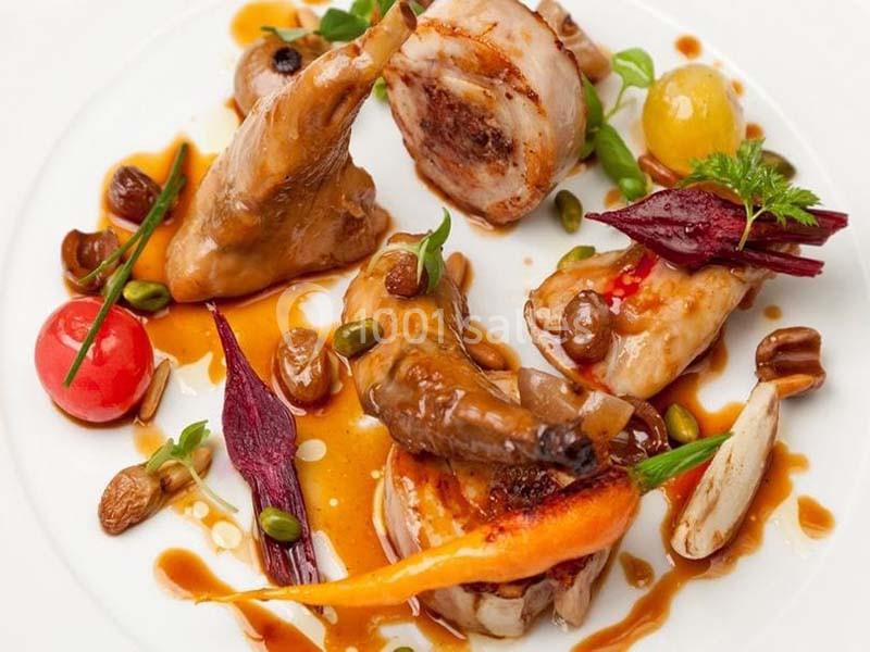 Assiette gastronomique composée de viande, légumes colorés, fruits secs et sauce dressée avec soin.