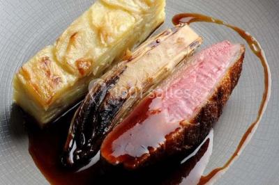 Gâteau de mariage décoré avec des choux, des fleurs en sucre et des cierges magiques allumés.