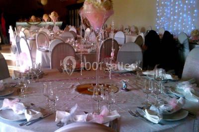 Gâteau de mariage décoré avec des choux, des fleurs en sucre et des cierges magiques allumés.