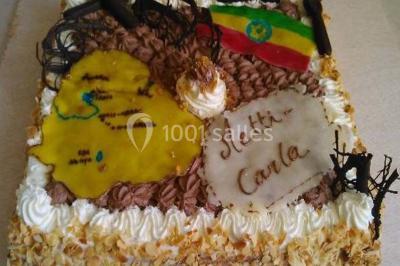 Gâteau de mariage décoré avec des choux, des fleurs en sucre et des cierges magiques allumés.