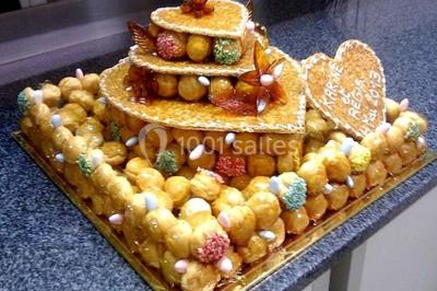 Gâteau de mariage décoré avec des choux, des fleurs en sucre et des cierges magiques allumés.
