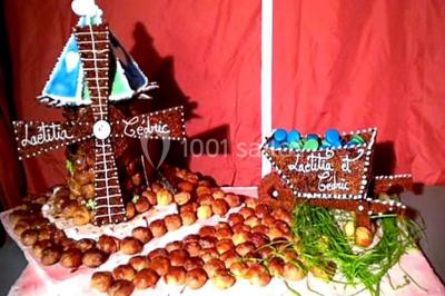 Gâteau de mariage décoré avec des choux, des fleurs en sucre et des cierges magiques allumés.