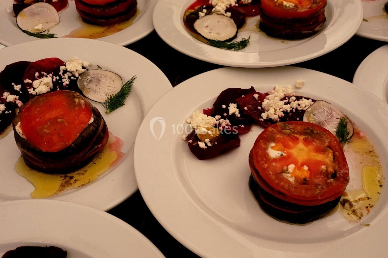 Assiettes de légumes grillés en couches avec tomates, betteraves, fromage émietté et herbes fraîches.