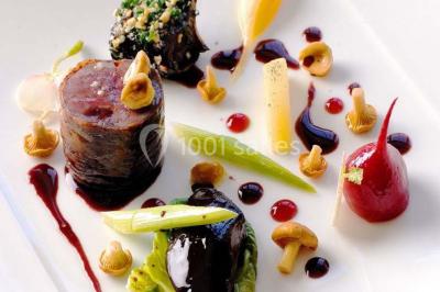 Gâteau de mariage décoré avec des choux, des fleurs en sucre et des cierges magiques allumés.