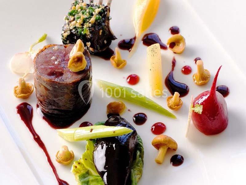 Assiette gastronomique composée de viande, légumes, champignons et sauces artistiquement disposés.