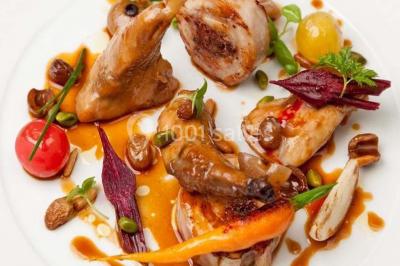 Gâteau de mariage décoré avec des choux, des fleurs en sucre et des cierges magiques allumés.