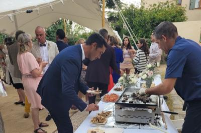 Gâteau de mariage décoré avec des choux, des fleurs en sucre et des cierges magiques allumés.