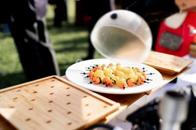 Assortiment de bouchées gastronomiques sur une planche en bois, incluant tartes aux légumes et poissons garnis.