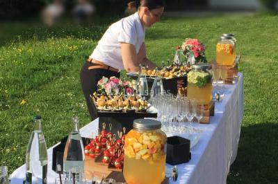 Assortiment de bouchées gastronomiques sur une planche en bois, incluant tartes aux légumes et poissons garnis.