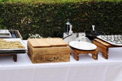 Assortiment de bouchées gastronomiques sur une planche en bois, incluant tartes aux légumes et poissons garnis.