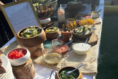 Assortiment de bouchées gastronomiques sur une planche en bois, incluant tartes aux légumes et poissons garnis.