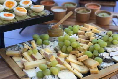 Assortiment de bouchées gastronomiques sur une planche en bois, incluant tartes aux légumes et poissons garnis.