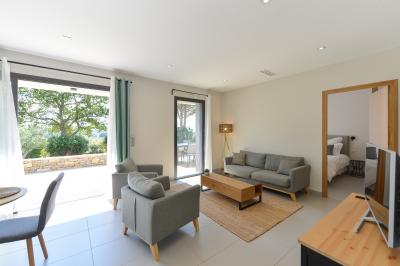 Salle de réception lumineuse avec murs en pierre, tables décorées de fleurs colorées et chandeliers suspendus.