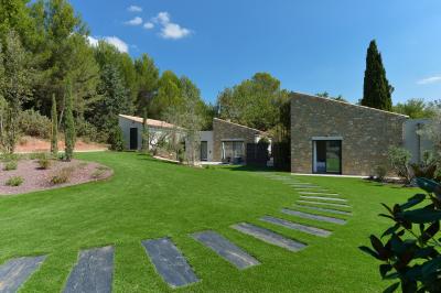 Salle de réception lumineuse avec murs en pierre, tables décorées de fleurs colorées et chandeliers suspendus.