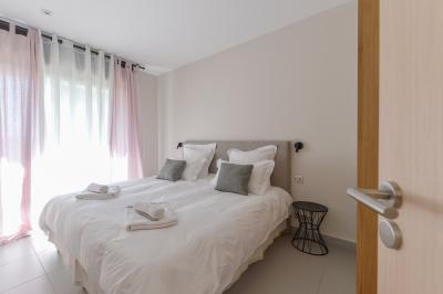 Salle de réception lumineuse avec murs en pierre, tables décorées de fleurs colorées et chandeliers suspendus.