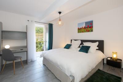 Salle de réception lumineuse avec murs en pierre, tables décorées de fleurs colorées et chandeliers suspendus.