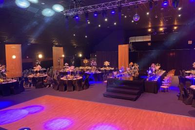 Salle de restaurant moderne avec des tables dressées, des chaises orange et un éclairage chaleureux.