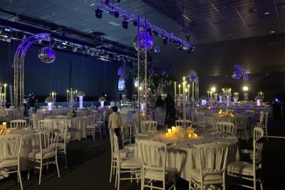 Salle de restaurant moderne avec des tables dressées, des chaises orange et un éclairage chaleureux.