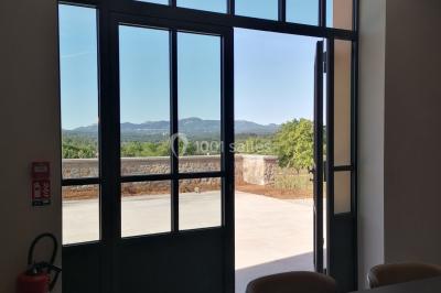 Escalier intérieur en pierre avec éclairage mural mettant en valeur des illustrations de paysages.