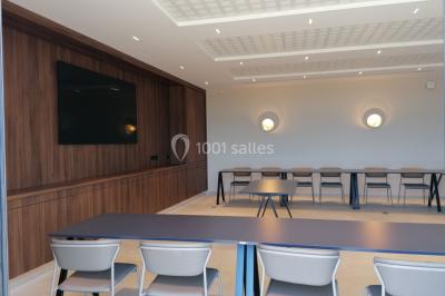 Escalier intérieur en pierre avec éclairage mural mettant en valeur des illustrations de paysages.