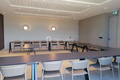 Escalier intérieur en pierre avec éclairage mural mettant en valeur des illustrations de paysages.