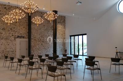 Escalier intérieur en pierre avec éclairage mural mettant en valeur des illustrations de paysages.