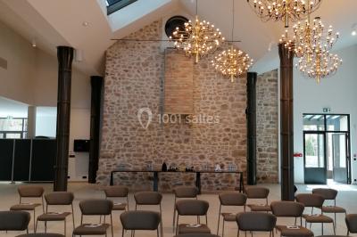 Escalier intérieur en pierre avec éclairage mural mettant en valeur des illustrations de paysages.