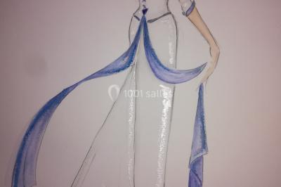 Mannequin vêtu d'une robe en dentelle blanche avec un voile noir couvrant la tête, devant une porte en bois clair.