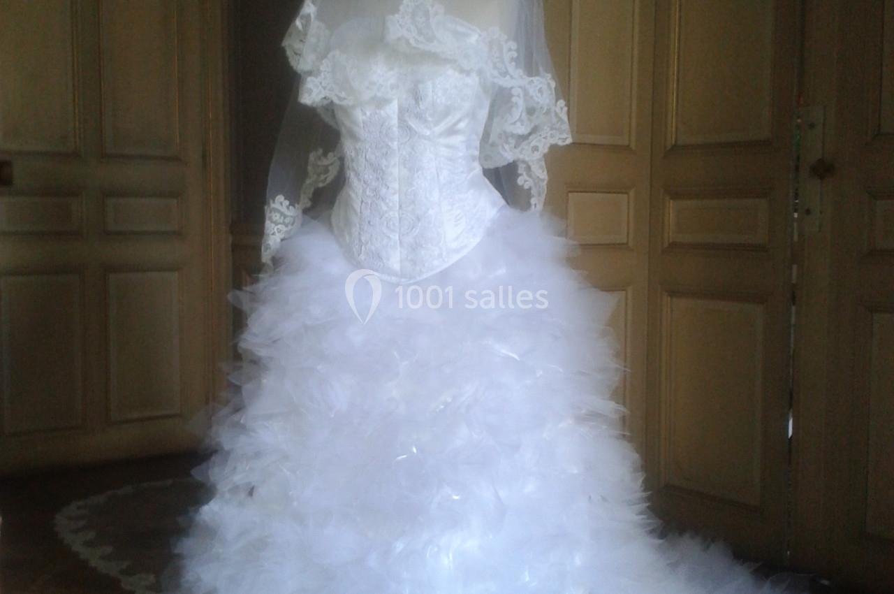 Robe de mariée blanche avec corset en dentelle et jupe volumineuse en tulle, présentée sur un mannequin.
