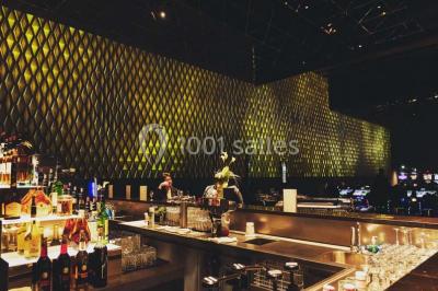 Salle de casino avec machines à sous, tables de jeu et décorations lumineuses évoquant des feux d'artifice.