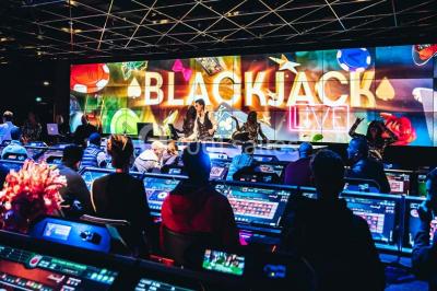 Salle de casino avec machines à sous, tables de jeu et décorations lumineuses évoquant des feux d'artifice.