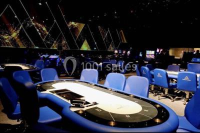 Salle de casino avec machines à sous, tables de jeu et décorations lumineuses évoquant des feux d'artifice.