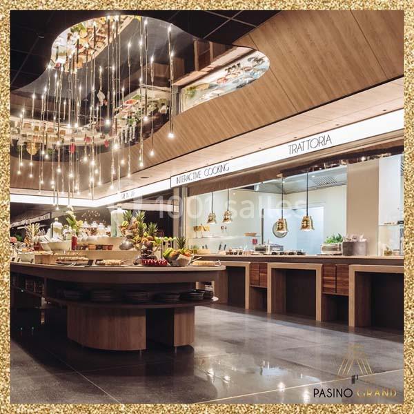 Buffet moderne avec plats variés, éclairage suspendu et cuisines ouvertes dans un cadre élégant.