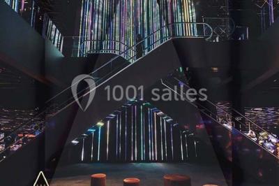 Salle de casino avec machines à sous, tables de jeu et décorations lumineuses évoquant des feux d'artifice.