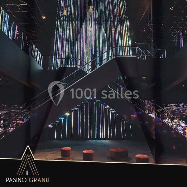 Escalier moderne illuminé par des lumières colorées dans un intérieur sombre et élégant.