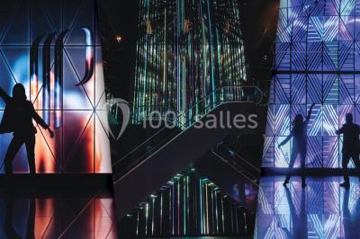 Salle de casino avec machines à sous, tables de jeu et décorations lumineuses évoquant des feux d'artifice.