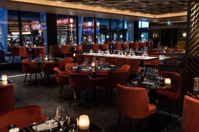 Salle de casino avec machines à sous, tables de jeu et décorations lumineuses évoquant des feux d'artifice.