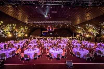 Salle de casino avec machines à sous, tables de jeu et décorations lumineuses évoquant des feux d'artifice.