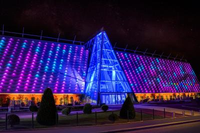Salle de casino avec machines à sous, tables de jeu et décorations lumineuses évoquant des feux d'artifice.