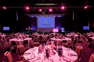 Salle de casino avec machines à sous, tables de jeu et décorations lumineuses évoquant des feux d'artifice.
