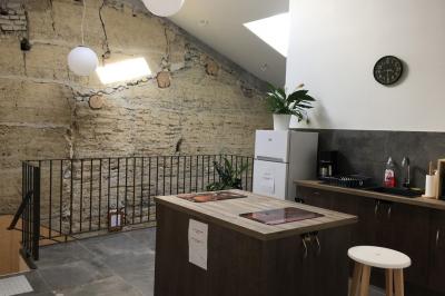 Cuisine équipée avec réfrigérateur, micro-ondes, cafetière, évier et plan de travail en bois, décor sobre et fonctionnel.