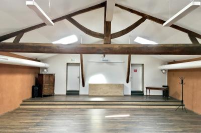 Cuisine équipée avec réfrigérateur, micro-ondes, cafetière, évier et plan de travail en bois, décor sobre et fonctionnel.