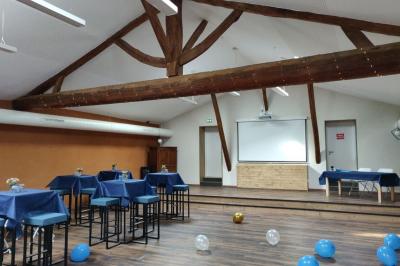 Cuisine équipée avec réfrigérateur, micro-ondes, cafetière, évier et plan de travail en bois, décor sobre et fonctionnel.