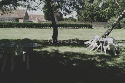 Canapé doré avec assise blanche devant un décor floral et un rideau blanc, éclairé par des appliques murales.