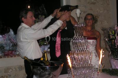 Canapé doré avec assise blanche devant un décor floral et un rideau blanc, éclairé par des appliques murales.